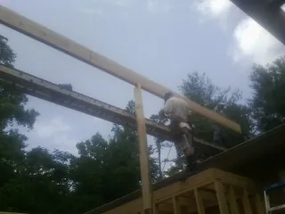 Carpenter setting a ridge beam over a new addition frame — Ice Dam Removal by Roofing Brothers in Churchton