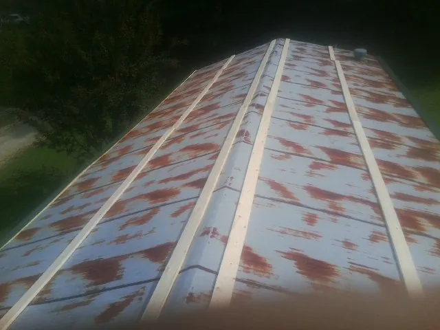 Rusted metal roof panels with new wood purlins before replacement — Storm Damage Roof Repair in Churchton by Roofing Brothers