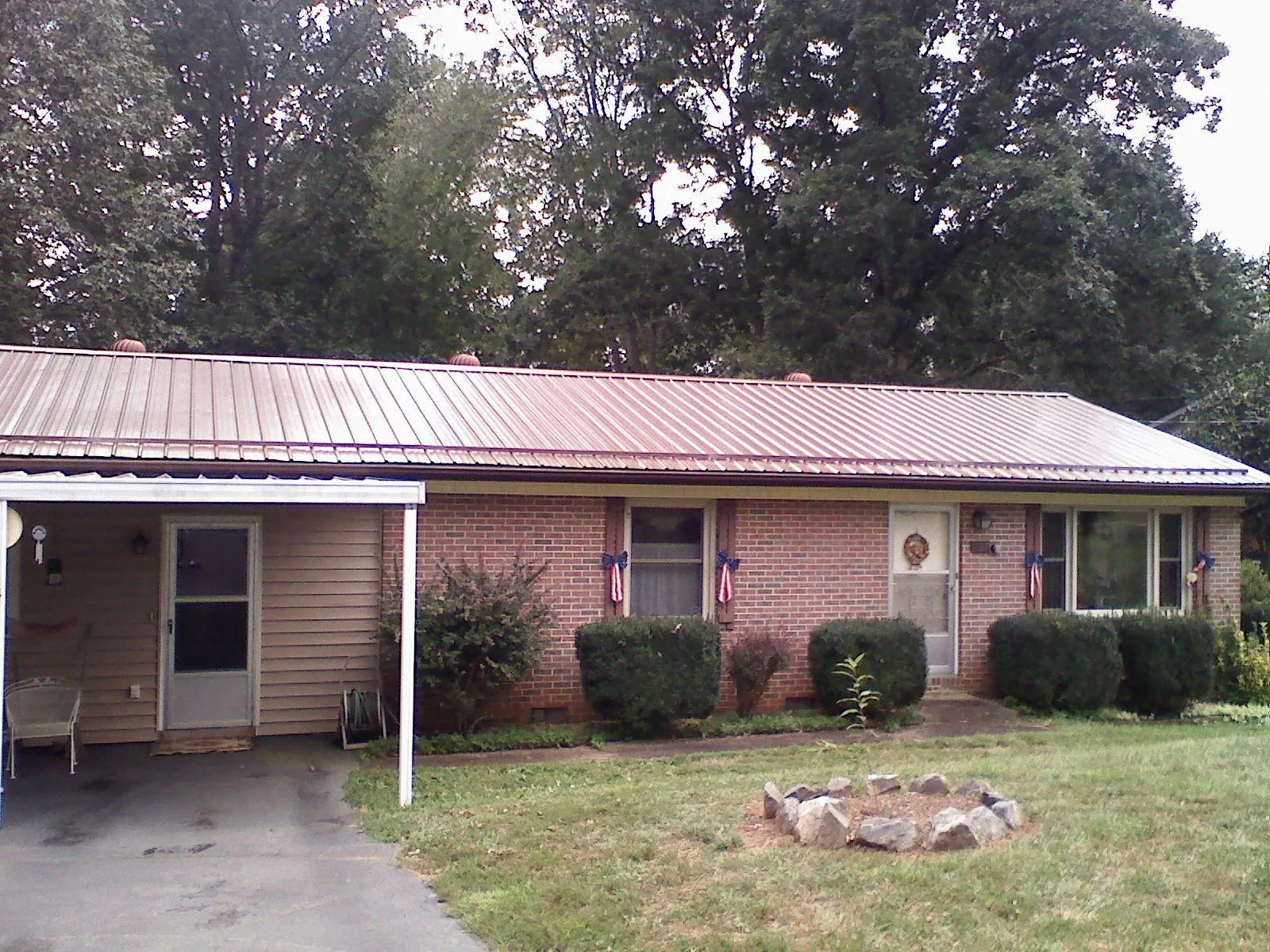 Bronze metal roof and carport on a brick ranch home — Roof Repair work by our crew in Churchton