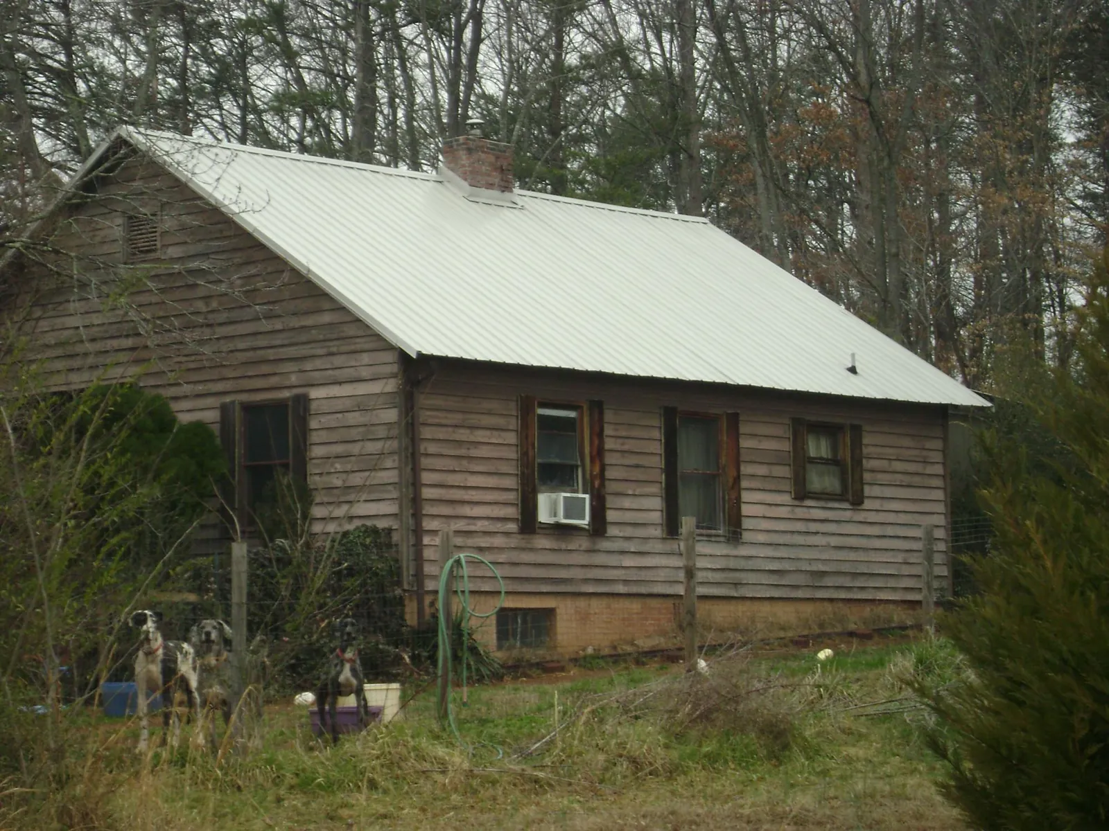 White metal roof on an old wood sided farmhouse, from a Metal Roof Installation job in Churchton